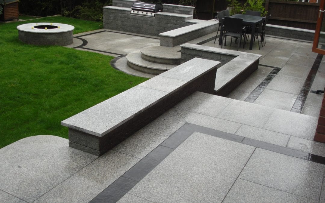 Tiered patio area in Granite with bespoke cut steps.