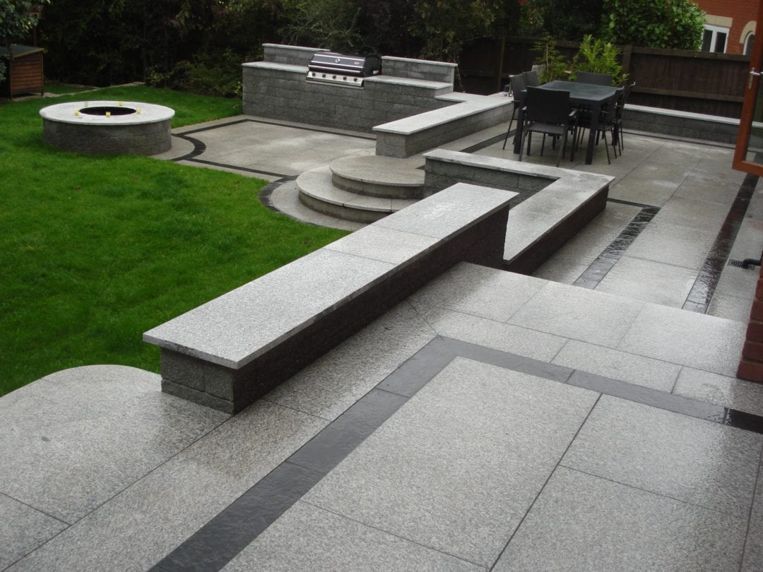 Tiered patio area in Granite with bespoke cut steps.